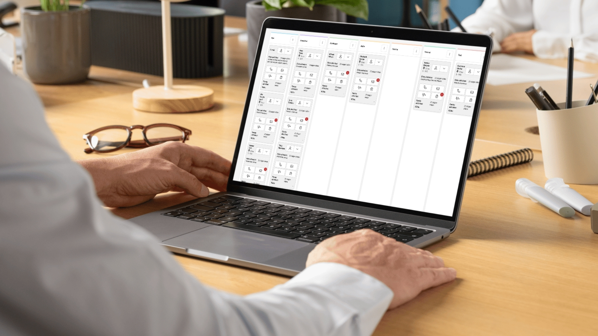Personne utilisant un ordinateur portable avec Kvass affichant la nouvelle fonctionnalité de pipeline de leads avec une vue kanban et un aperçu des acheteurs potentiels dans différentes phases de vente.